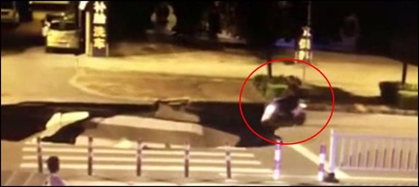 VIDEO: Man busy on phone drives his scooter right into giant sinkhole in China