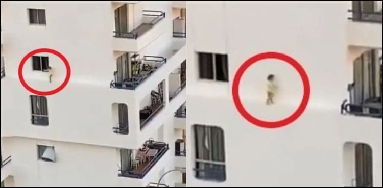 Terrifying video shows toddler walking on apartment's thin ledge    