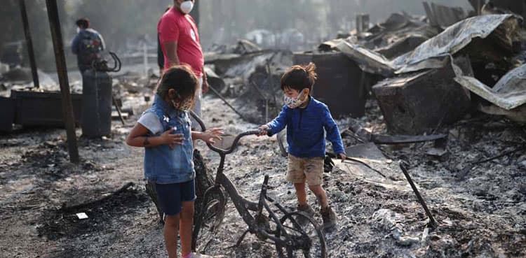Scores of wildfires scorch U.S. West Coast, killing at least nine