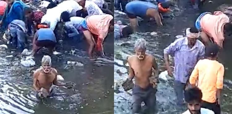WATCH: People jump into drain water to collect currency notes