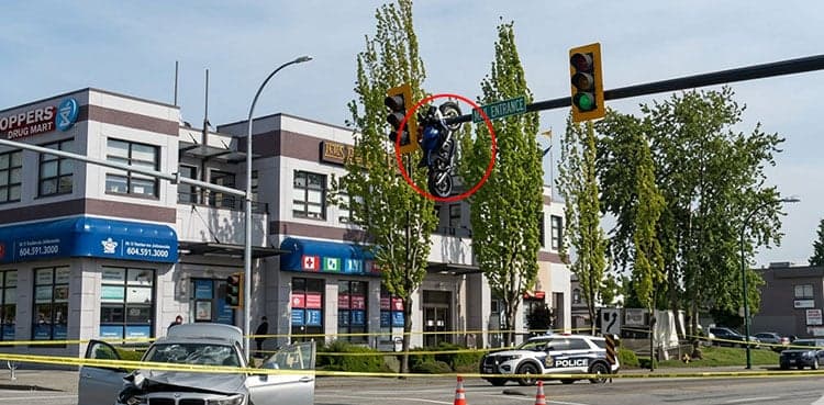 Viral video shows motorcycle dangling from traffic signal pole after shocking crash