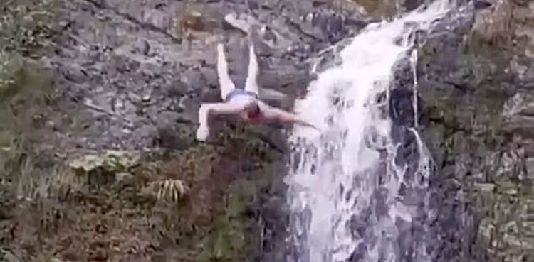 tourist head on rocks diving waterfall video