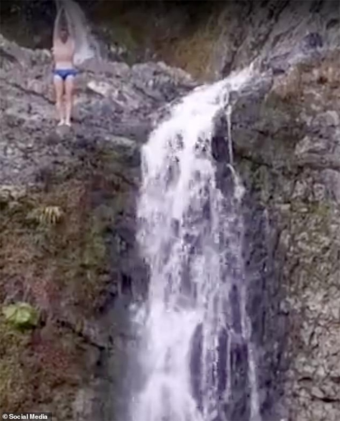 tourist head on rocks diving waterfall video