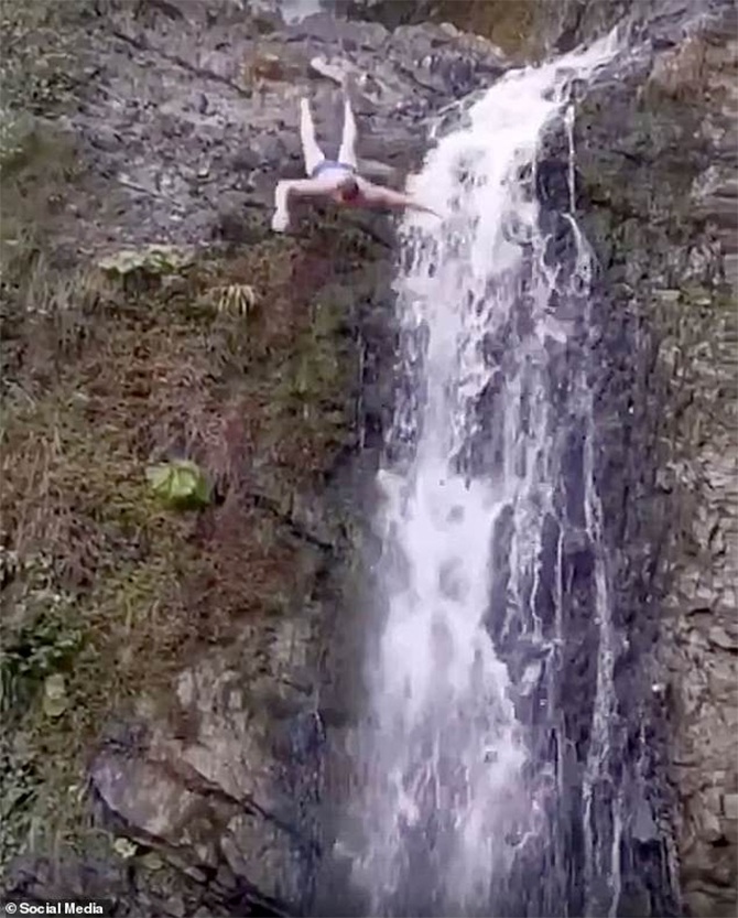 tourist head on rocks diving waterfall video