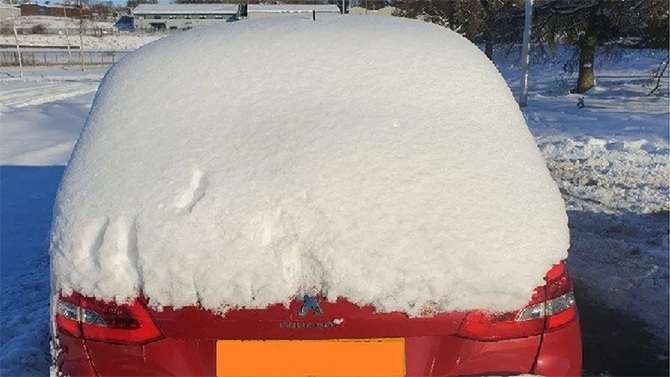 man driving snow-covered car zero visibility